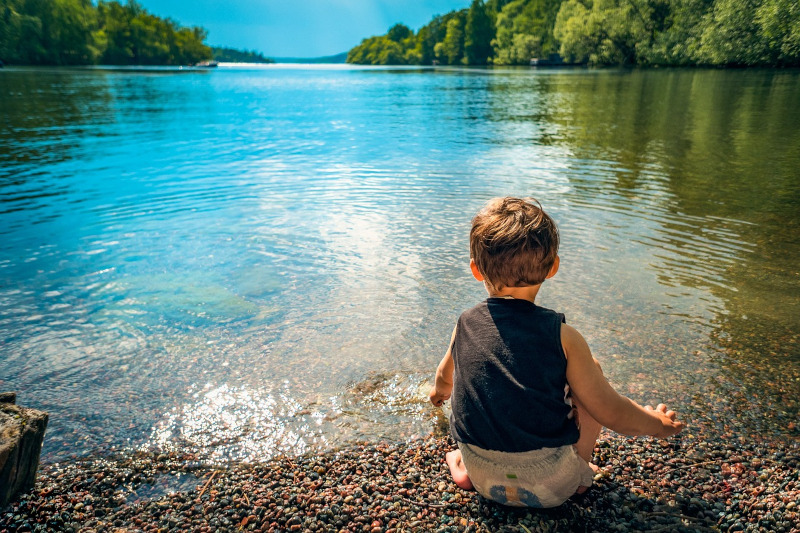 niño delante de un lago